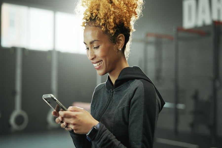 Kvinna letar efter träningskompis i GymMap-appen på gymmet